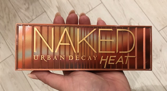 urban decay heat palette with the lid closed sitting in the palm of my hand