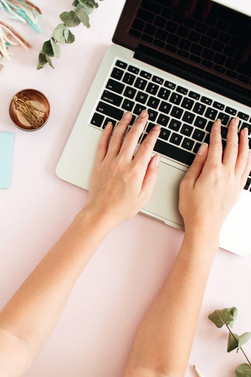 hands leaning on a laptop writing