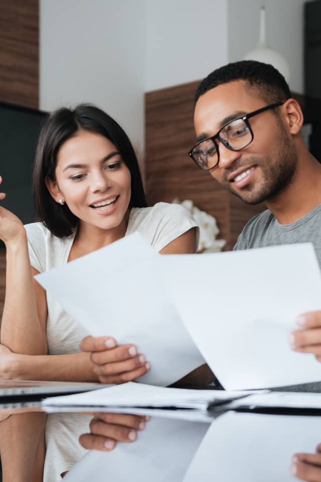 a couple sitting together at a table discussing their finances