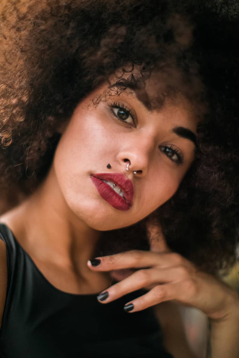 A close up of a ladies face with multip;e piercings