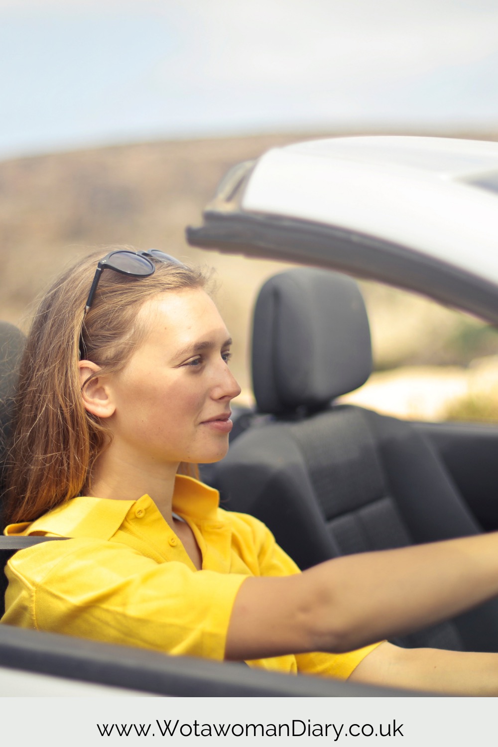 a lady sitting in her car looking forward on her road trip