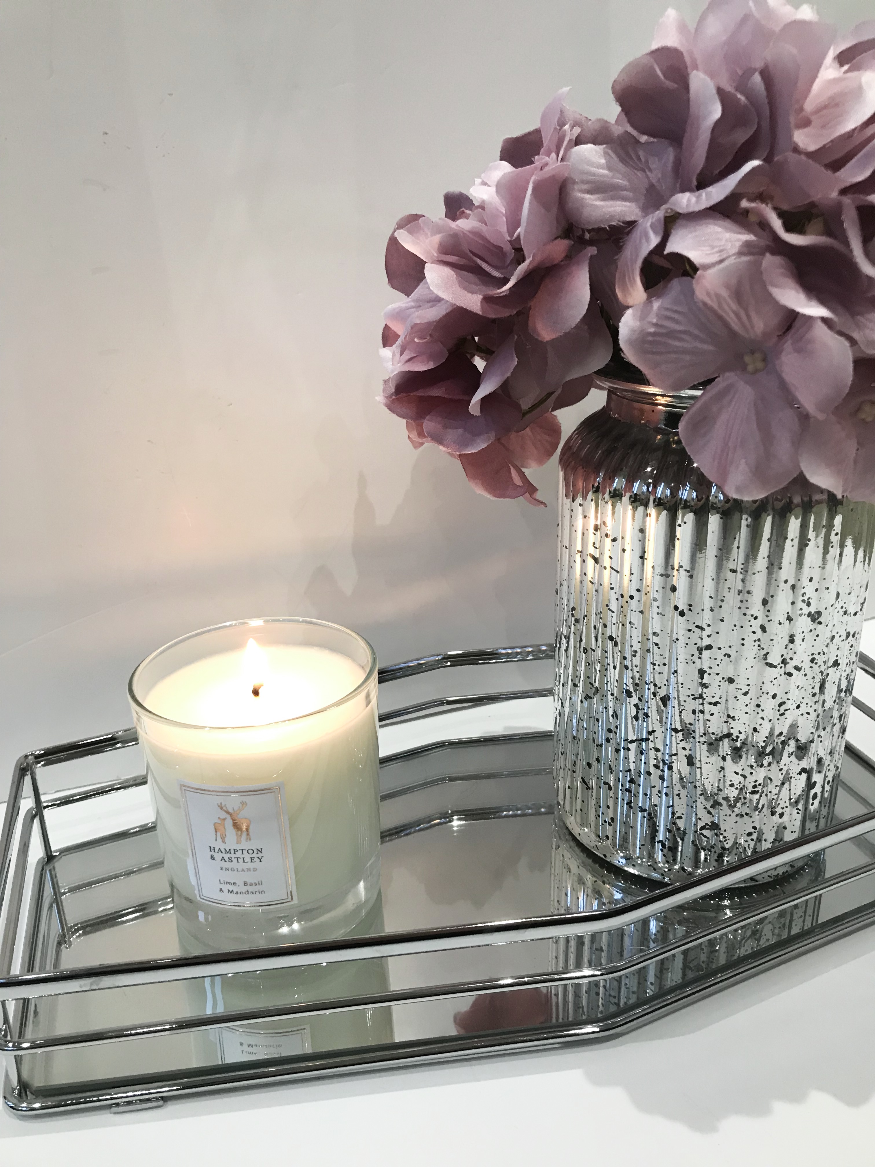 Hampton and Astley Candle displayed on a tray next to an autumnal loooking bouquet