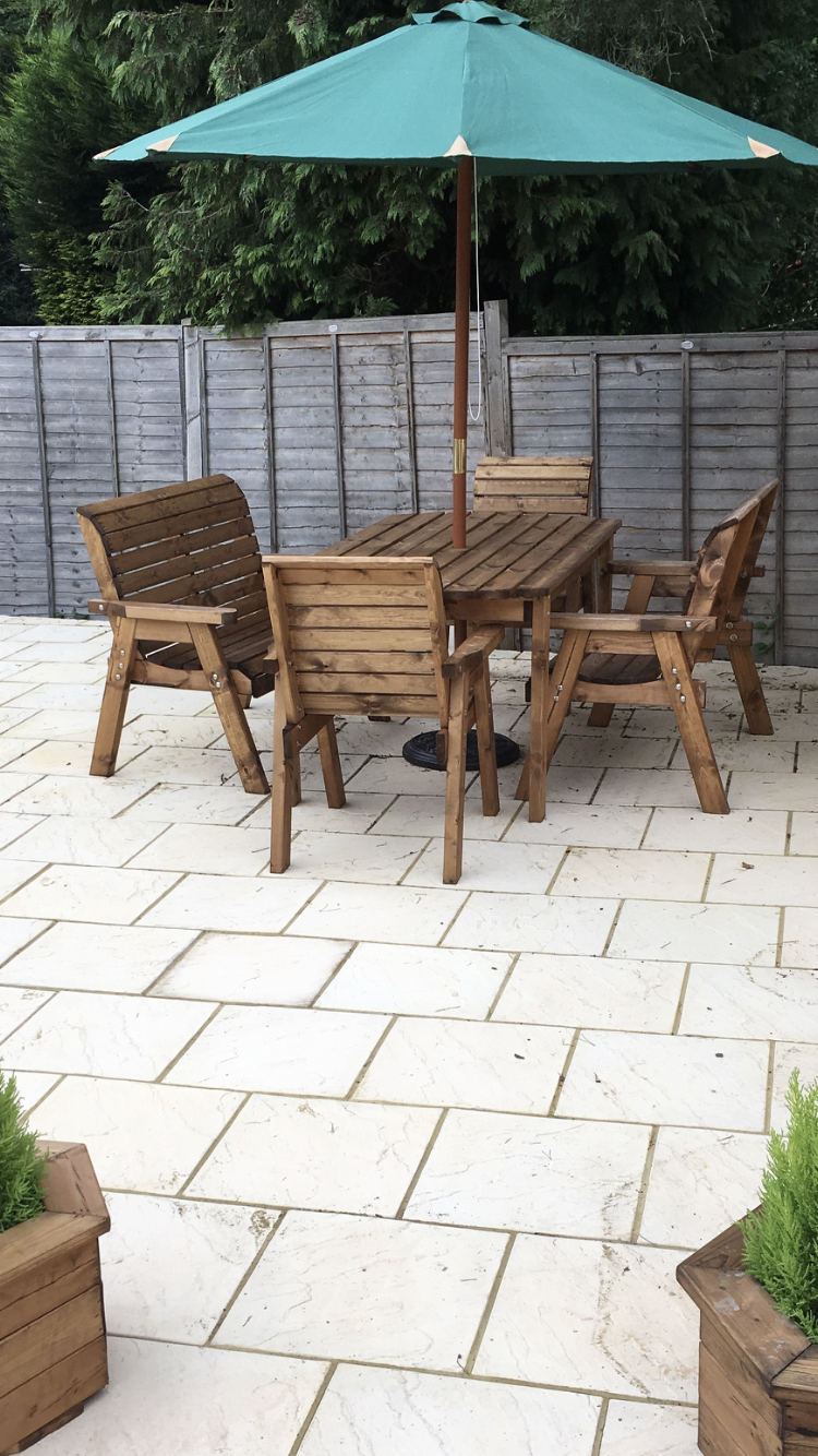 Wooden garden furniture set up on a patio area in the garden