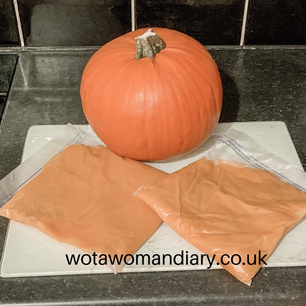 2 bags of pumpkin puree sitting on a worktop with a whole pumpkin in the back ground
