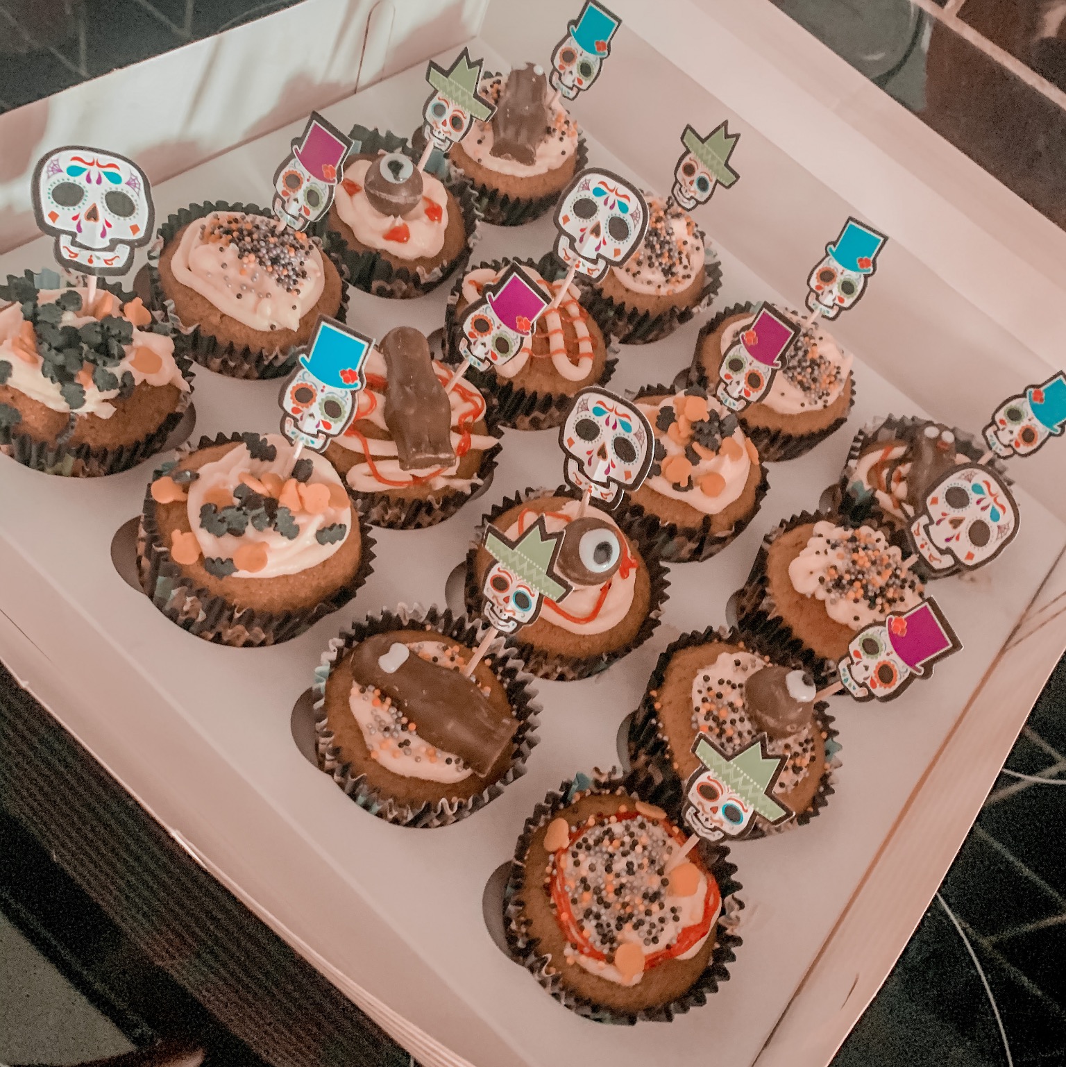 a tray of halloween inspired pumpkin cupcakes