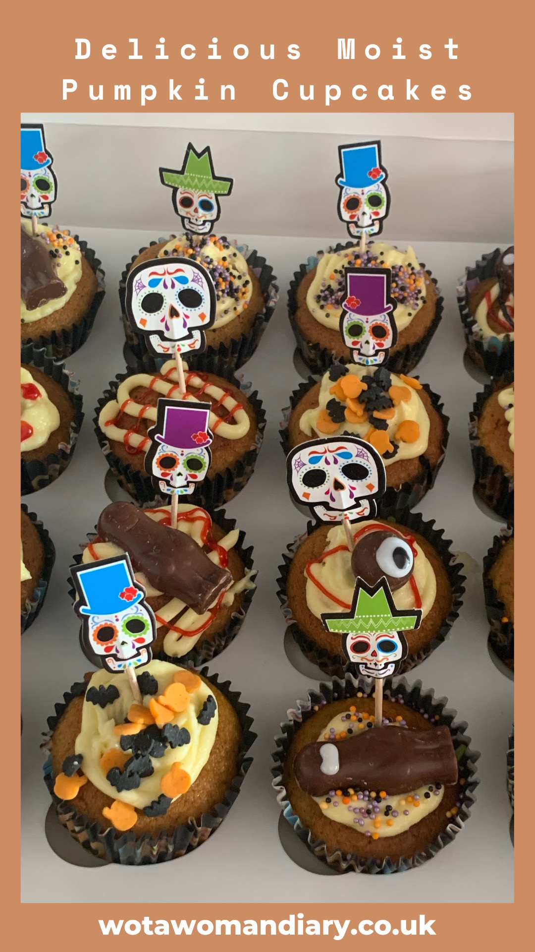 a tray of decorated pumpkin cupcakes looking delicious