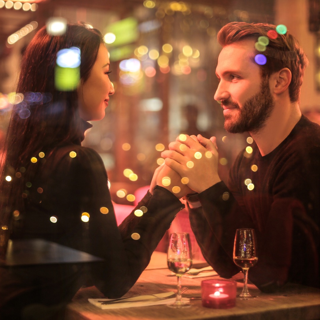 a couple holding hands across a table on date night