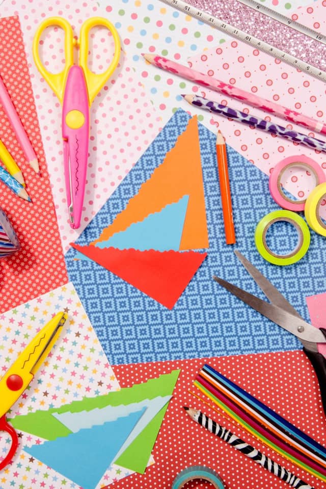 loads of brightly coloured arts and craft supplies spread out on a table
