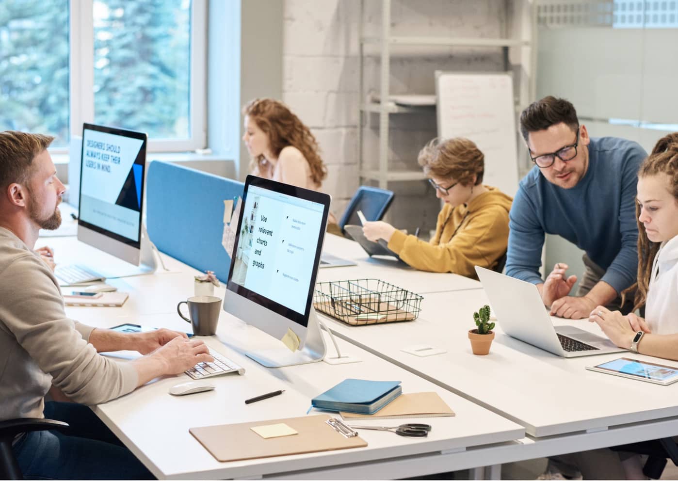 a group of people all sitting at desks looking at computers