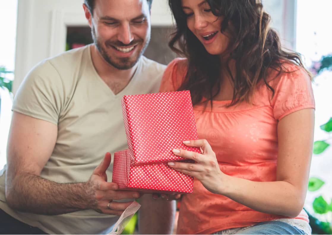 anniversary gift ideas being presented to a wife by her husband