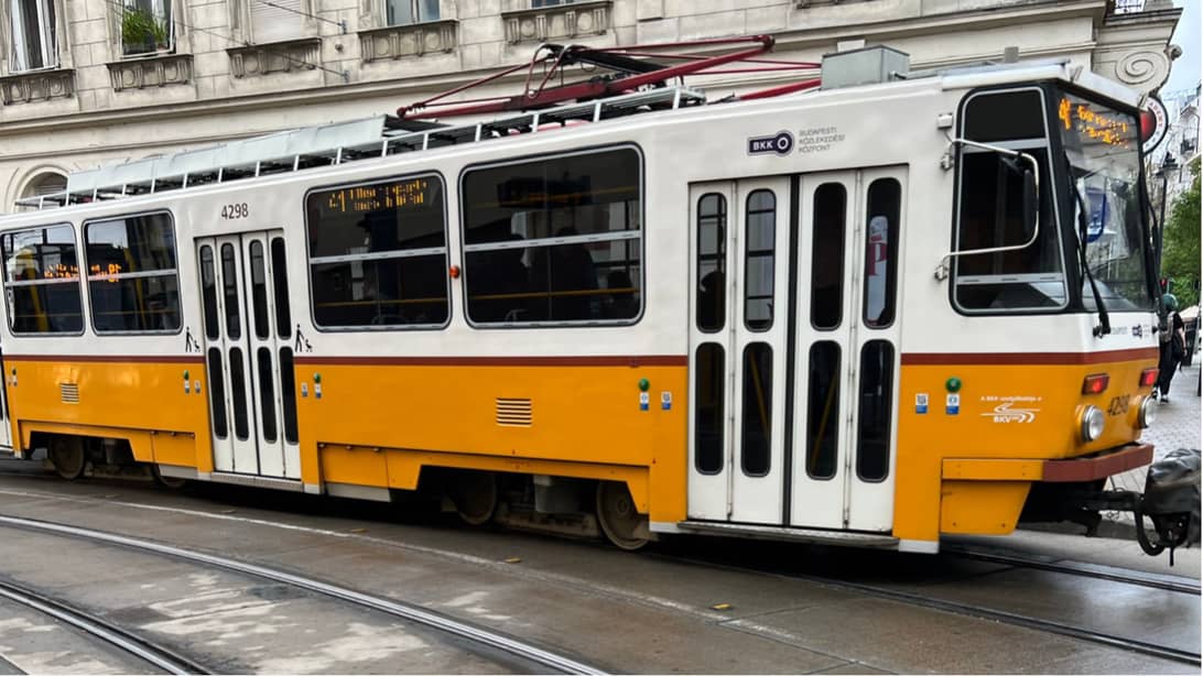 an old yellow and white tram in use in Budapest