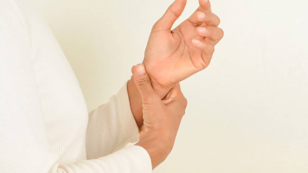 a lady over 40 holding her wrists