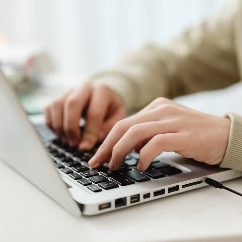hands typing on a laptop